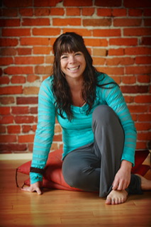 Cyndi Parris, LMT — seated in a warm studio with exposed brick